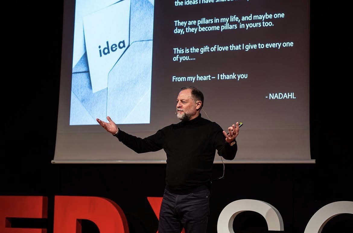 Nadahl Shocair speaking on a TEDx stage